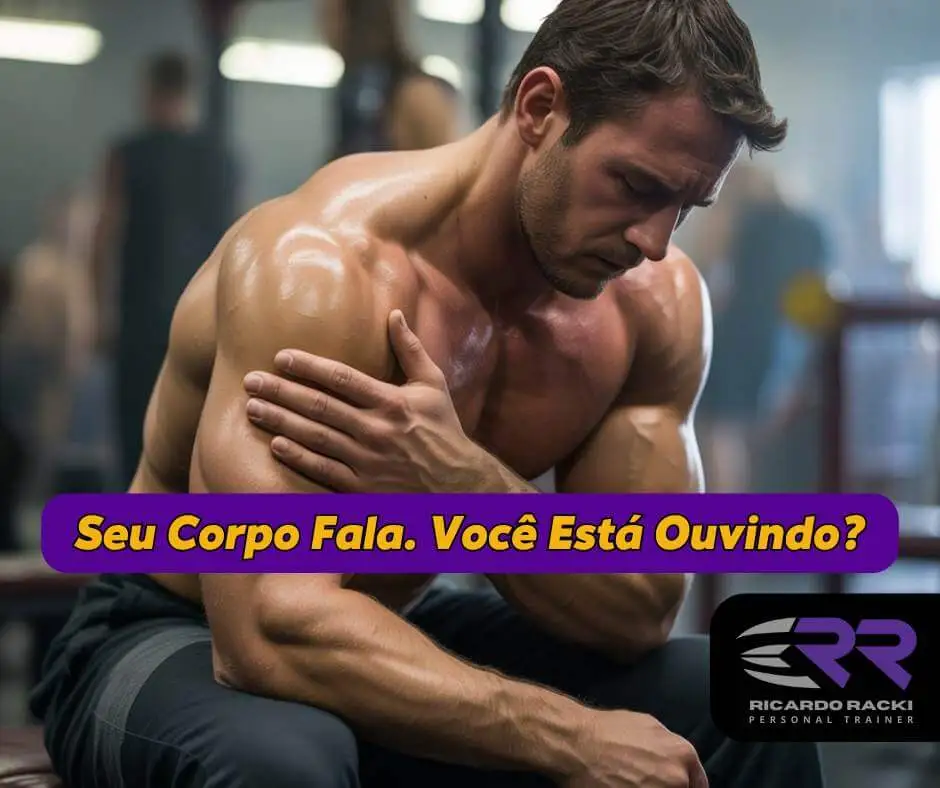 Homem musculoso sentado em academia tocando o ombro com expressão de dor, representando escuta corporal e prevenção de lesões durante o treino.